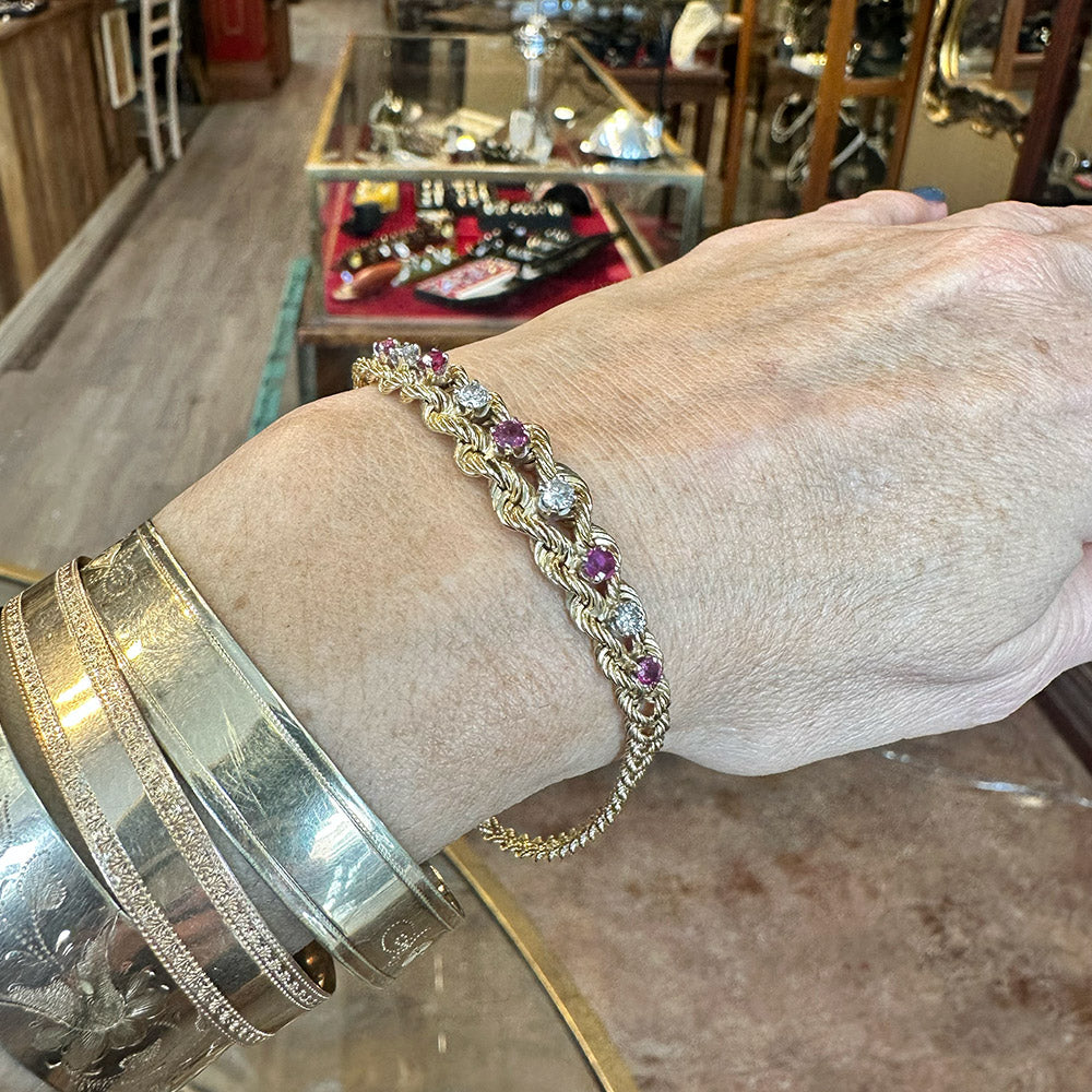 Hand wearing a silver bracelet with purple and clear stones in a jewelry store Upstate NY.