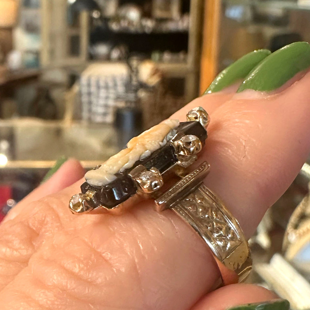 Close-up of a hand wearing an antique gold ring with intricate designs in an indoor setting Upstate New York.