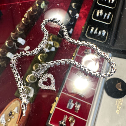 Silver and 10k diamond bracelet with heart charm on a jewelry display box at Saugerties Antiques Center.