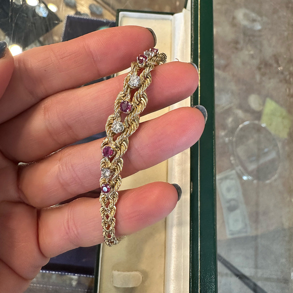 Gold bracelet with gemstones held by a hand against a blurred background Upstate New York.