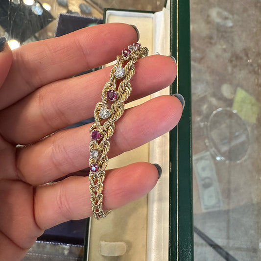 Gold bracelet with gemstones held by a hand against a blurred background Upstate New York.