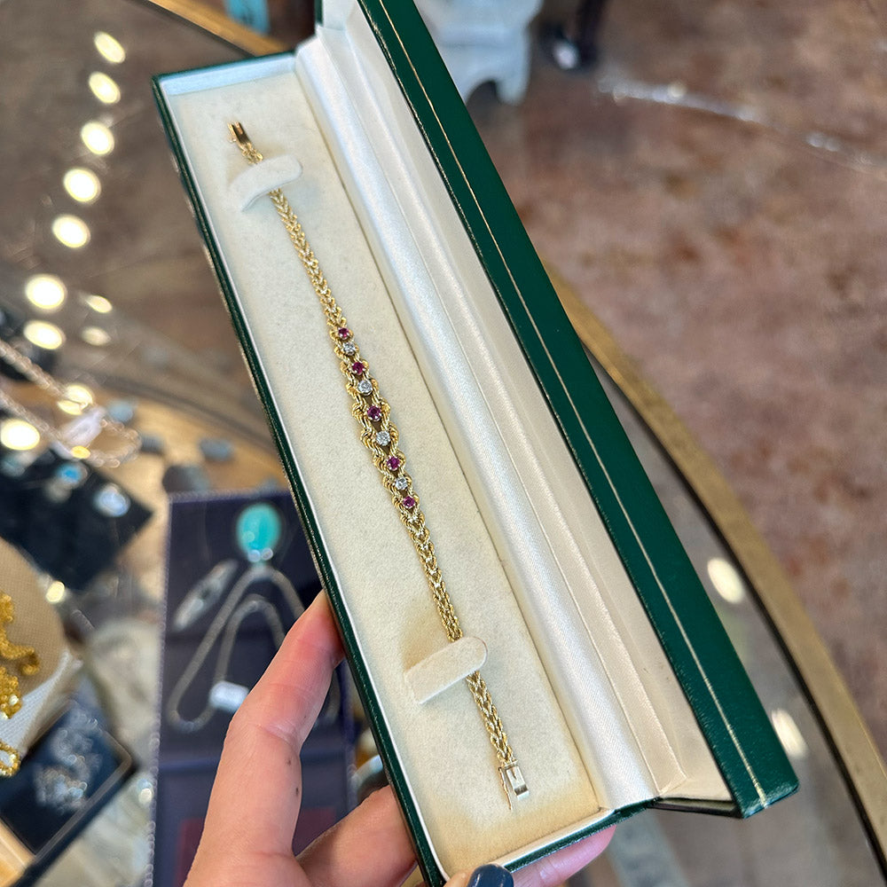 Gold bracelet with gemstones in a green jewelry box held by a hand inside of an antique store in Upstate New York.