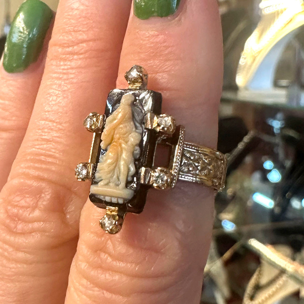 Side-view of a gorgeous antique ring in gold with diamonds and mother and child carving.